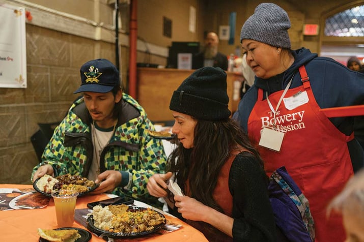 Volunteer serving guests a Thanksgiving meal