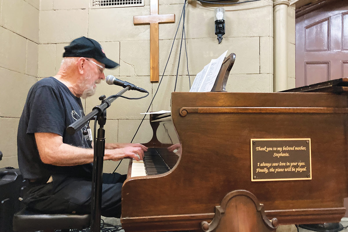 Bob, a volunteer, playing the piano at The Bowery Mission