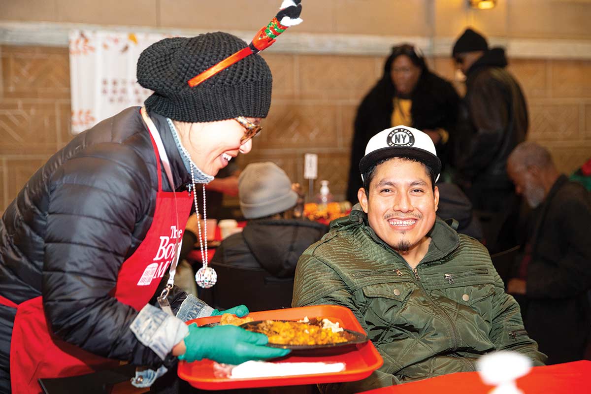 Volunteer serving Thanksgiving meal to guest