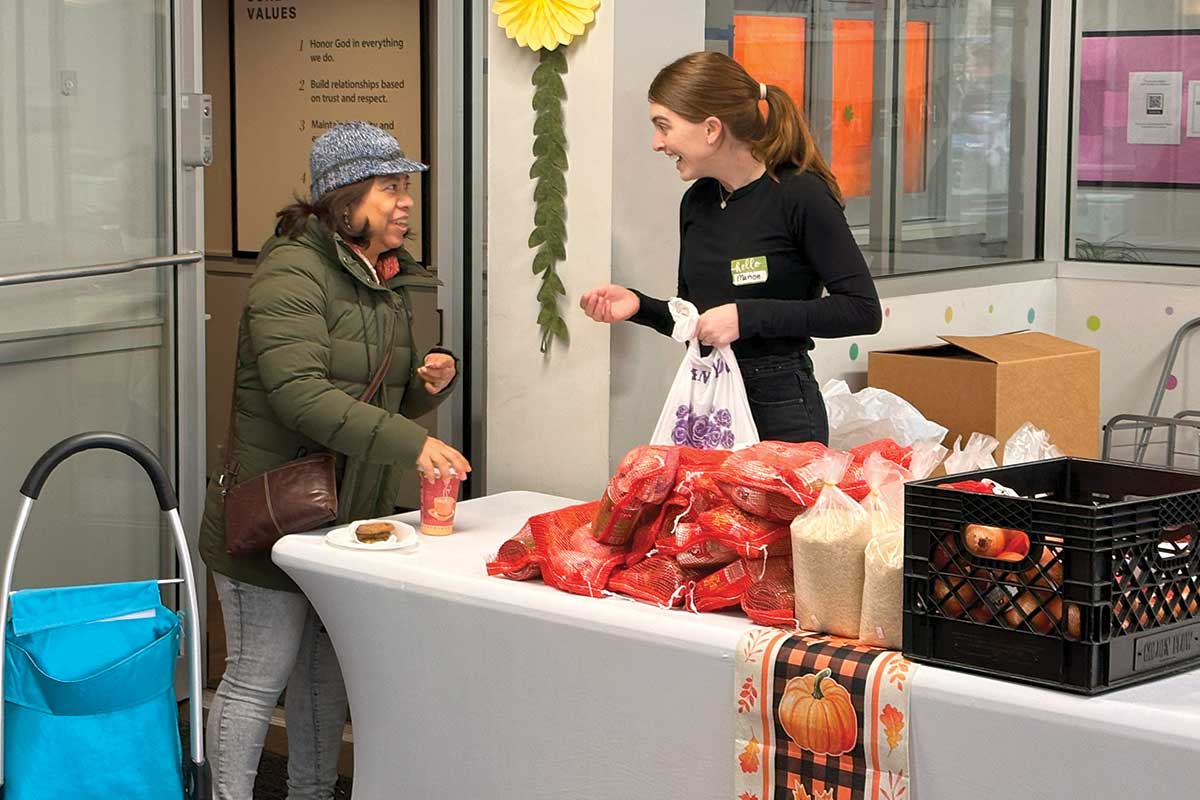 Woman receiving Thanksgiving supplies from volunteer