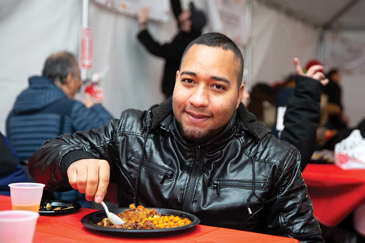 Guest smiling and eating Thanksgiving meal