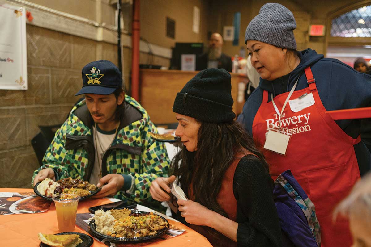 Volunteer serving Thanksgiving meal to guest